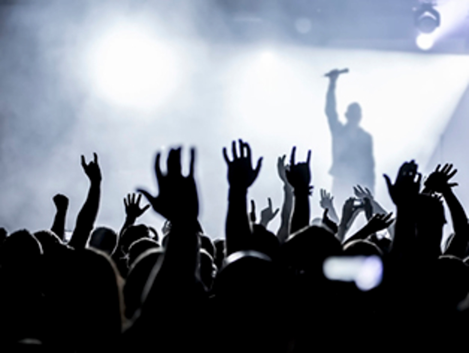 audience cheering a band on stage